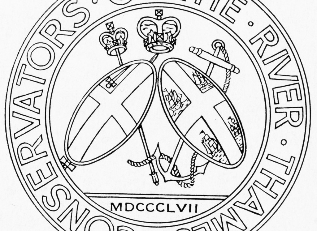 Black and white circular logo with ‘Conservators of the River Thames’ around the outside edge. In the centre are two shields in front of a sceptre and an anchor with rope. The left shield has a single sword on it and a cross. The right shield has four boats and a cross on it. Above the shields, at the centre, is a crown. Below the shields is ‘MDCCCLVII’.