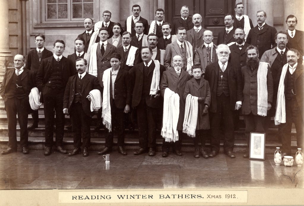 Black and white group photograph of members the Reading Winter Bathers club, all men, some younger boys, dressed in smart attire holding towels. Label reads: Reading Winter Bathers, Xmas 1912.